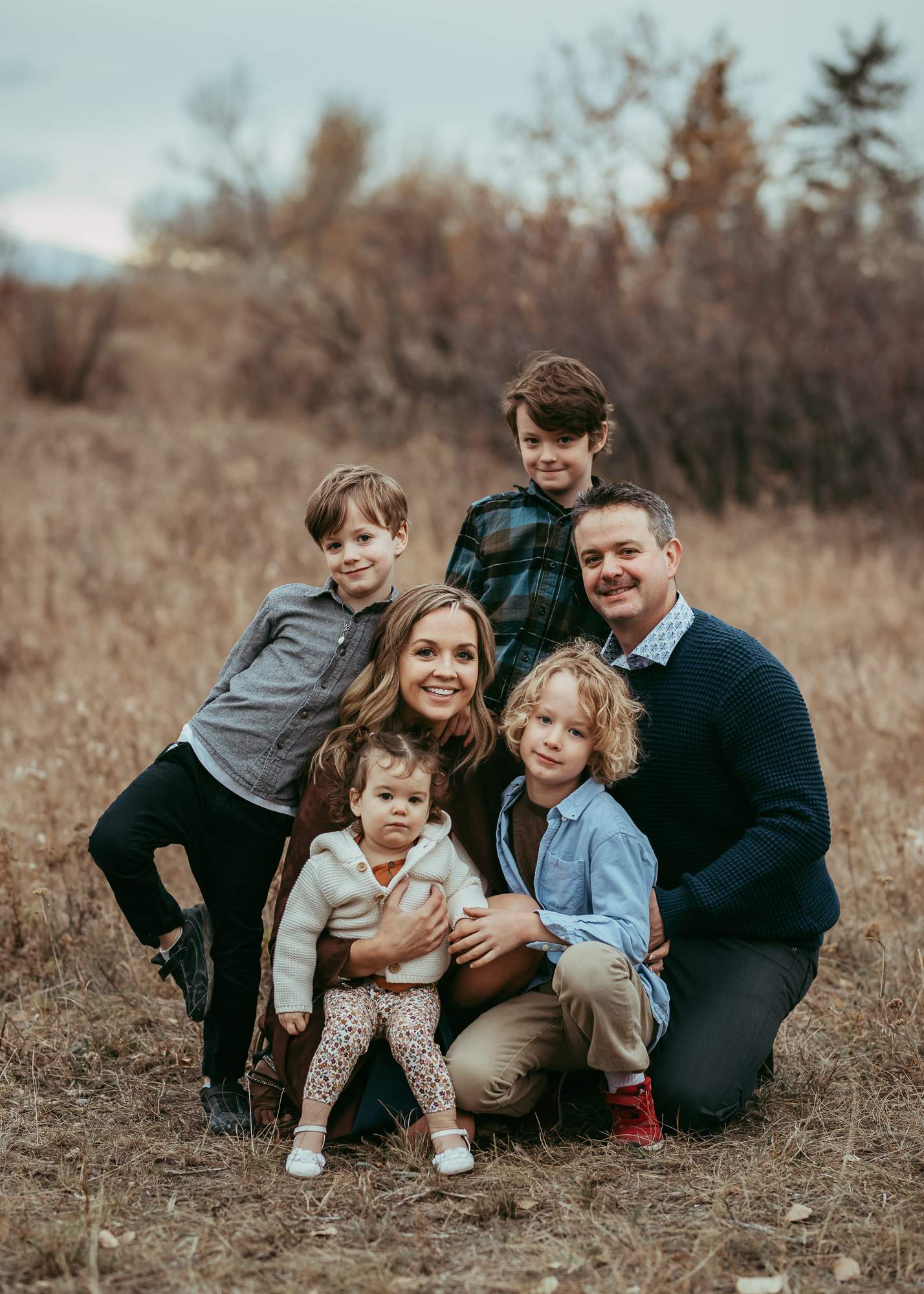 Chelsea Binotto, founder of Borealis Blooms, with her husband and four children in a golden prairie field